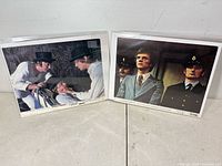 Two lobby cards in plastic sleeves, showing scenes from A Clockwork Orange and O Lucky Man!