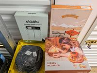 Four boxed poultry care items: incubator, brooder heater plate, coop door, brooder box mat