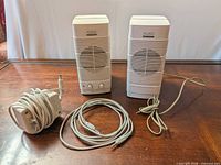 Front view of both speakers, AC adapter and audio cable