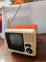 Front and side view of red and cream JVC portable TV with extended antenna