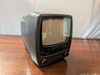 Front three-quarter view showing CRT screen, control panel, knobs and branding