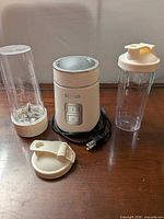 Motor base, blade assembly attached to cup, extra cup and lids
