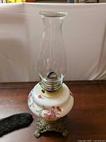 Full lamp showing chimney, milk glass font, and ornate base