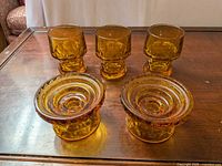 All five amber glass candle holders displayed on table