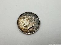 Obverse view showing Kennedy profile, date 1964, heavy toning
