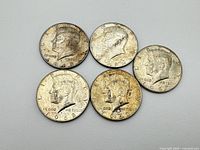 Five Kennedy half dollars dated 1966-1968 laid out