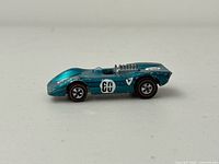 Left side profile showing metallic teal Ferrari with 60 decal and redline wheels