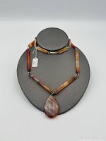 Full view of necklace on display bust showing overall design and pendant