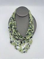Necklace displayed on bust showing multi-strand design and bead materials