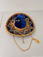 Top view showing blue velvet sombrero with gold embroidery and chin cords