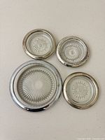 Set of four glass coasters showing size variation and starburst pattern