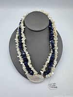 Full view of necklace displayed on bust showing bead arrangement and pendant