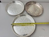 Three Gorham platters with tape for scale