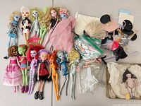 All dolls laid out with bags of accessories and boxed porcelain doll
