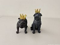 Both dog figurines side by side showing crowns and overall form