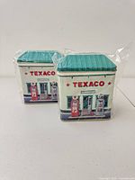 Two sealed Texaco tins front view