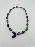 Full view of amethyst bead necklace laid flat