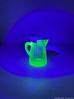 Pitcher glowing under UV light highlighting uranium content