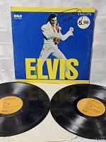 Front cover showing Elvis photo, handwriting, price circle and both records