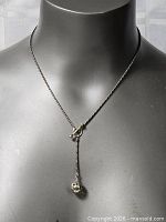 Full view of necklace on bust showing drop and pendant