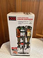 Front of boxed OGGI 6 Bottle Revolving Liquor Dispenser showing product image and features