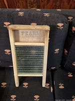 Front view of Pearl Canadian glass washboard showing wooden frame, printed logo and ribbed glass panel