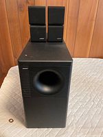 Front view of Bose Acoustimass subwoofer with two cube speakers stacked on top