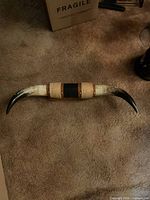 Full view of mounted bull horns showing horn coloration and center wrapping