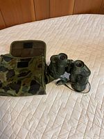 Binoculars on top of open camouflage case showing overall design
