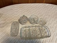All five clear pressed-glass pieces arranged on surface