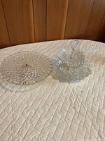 Top view of round pressed crystal cake stand and stack of lotus plates on tier rod