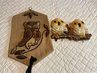 Ceramic owl key holder and woven owl wall hanging laid on quilted surface
