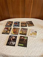 All ten DVD cases laid out on quilted surface, covers visible