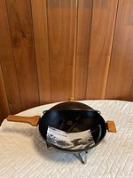 Electric wok with wood handles on metal stand, instruction manual inside
