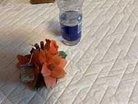 Orange ceramic lily arrangement next to water bottle for scale