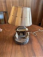 Full view of carved wood lamp with stitched wood shade and cord
