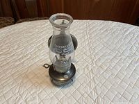 Full view of hanging oil lamp with metal base and Calvert Extra glass chimney