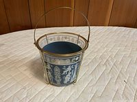 Overall view of blue jasperware ice bucket with white relief decoration and brass tripod stand