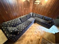 L-shaped navy patterned sectional couch on carpeted floor