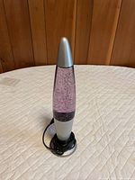 Full view of purple glitter lava lamp standing on table