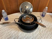 Nested Starfrit The Rock non-stick fry pans with matching lids