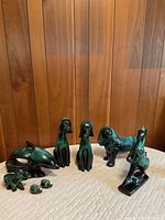 Group shot of all seven Blue Mountain Pottery figurines on quilted surface