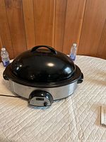 Full view of Rival stainless steel electric roaster with black lid and control panel