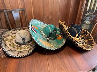 Three sombrero hats arranged on wooden surface