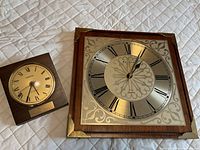Bulova square wood wall clock and Hampton small wood quartz clock side by side