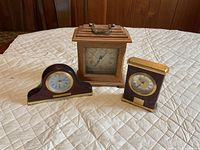 Front view of three wooden quartz clocks