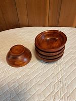 Four wooden salad bowls, one flipped to show base