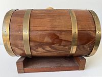 Side view showing wood grain, three brass bands, stand