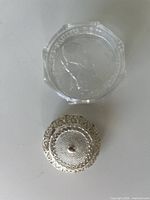 Clear plastic presentation box lid showing raised Pope John Paul II image and silver filigree case top view