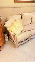 Left side of rattan bamboo sofa with cushions and throw pillow